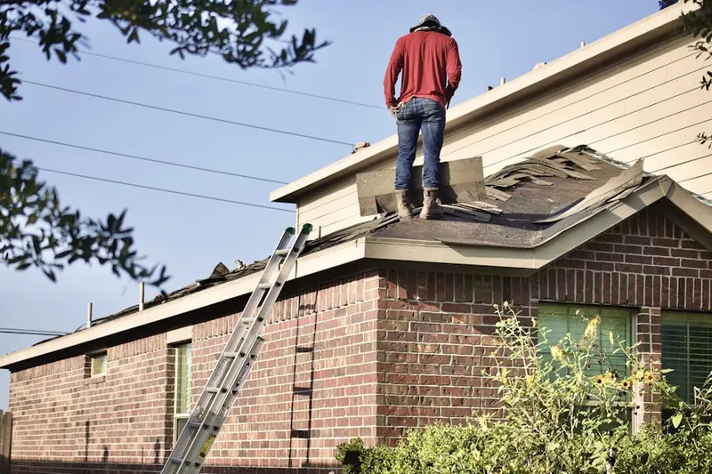 Professional roofer working on a residential roof in Gratz